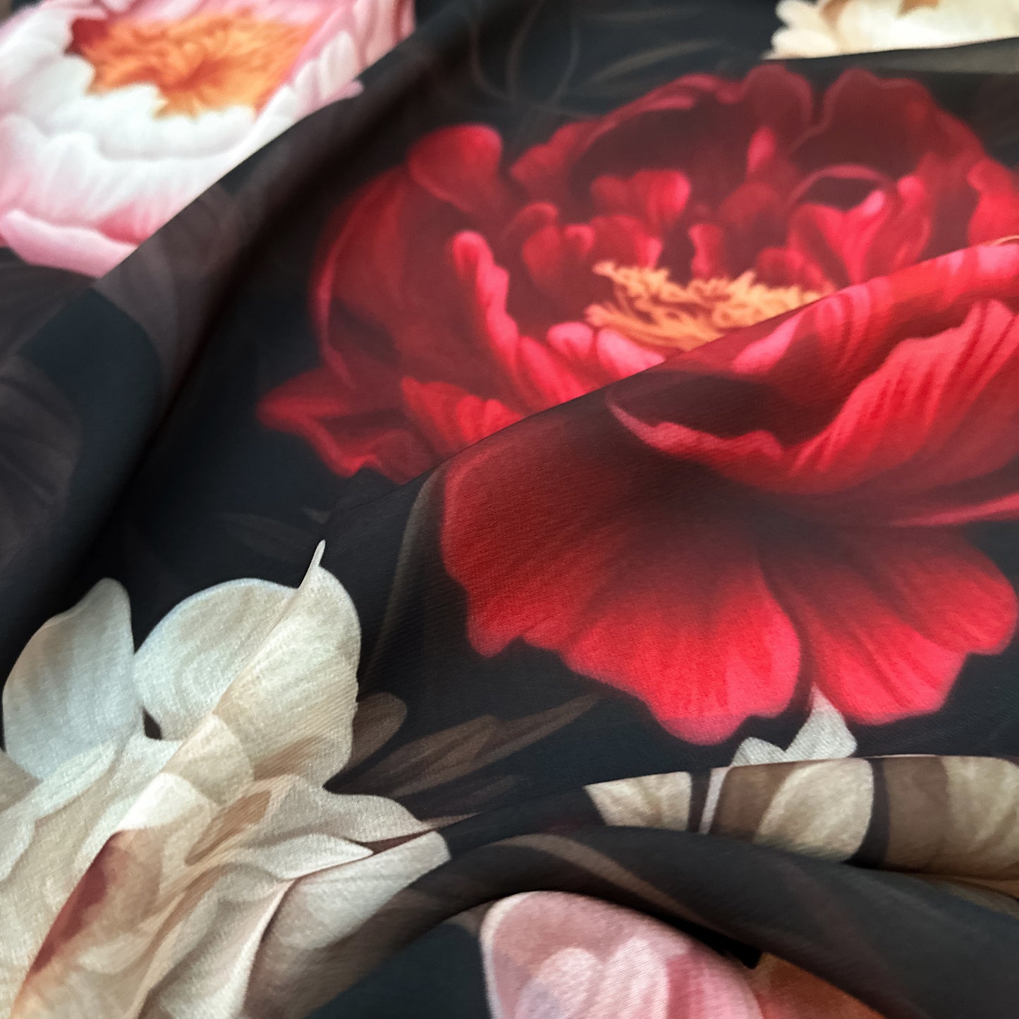 Garden Glory – floral design on sheer chiffon fabric with bright red, orange, and cream flowers on a dark background, lightweight and airy texture, design by Sewing Club.